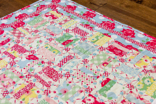 Beautiful crib quilt in reds, blues, greens and yellows based on the pattern Woven In