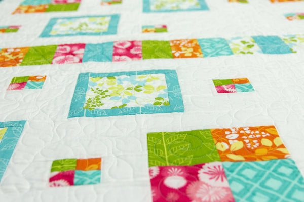 Colorful patchwork quilt with various patterns on a white background
