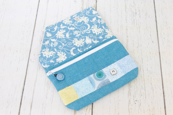 Sweet clutch purse to tuck under your arm or carry with pretty blues and green fabrics! A stylish way to carry your essentials!