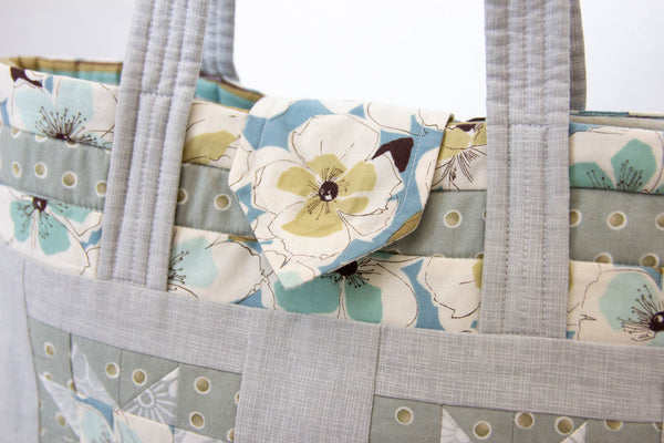 Small open tote bag in grey, blue and green with a small snap flap closure perfect for a quick trip to the store!